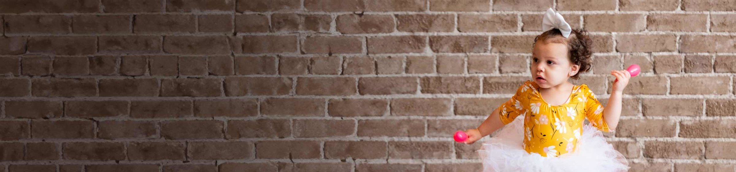 Aniya, a child with SMA, dancing with pink maracas in a ballerina outfit