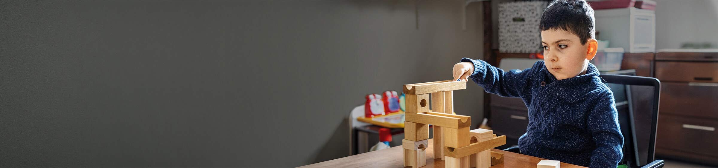 Donovan, a child with SMA, playing with toy blocks